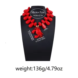 Dettaglio della collana di perline rosse con lunghezza 38+7cm e ciondolo a granchio