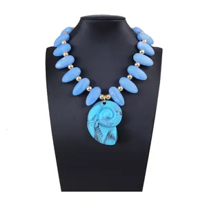 Vue détaillée d'un collier pendentif nautile bleu avec de grandes perles sur un buste