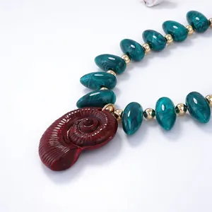 Gros plan détaillé du collier de perles en résine avec pendentif nautile de style marin