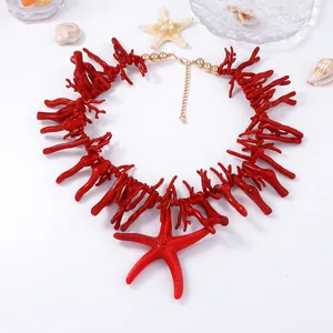 Détail du collier en résine de corail rouge avec pendentif étoile de mer et billes dorées