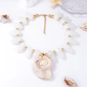 Vue détaillée d'un grand pendentif coquillage naturel avec collier perlé blanc et or océan