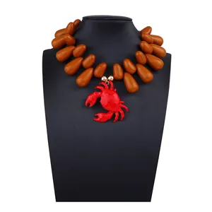Dettaglio della collana di perline con perle marroni a goccia e ciondolo a granchio