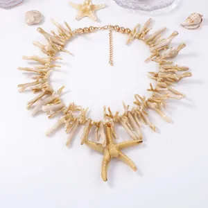 Détail du collier blanc style corail avec pendentif étoile de mer et chaîne dorée