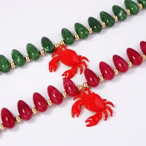 Ensemble de colliers en perles avec pierres vertes et roses et pendentifs crabe rouge