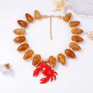 Collier style station balnéaire avec perles ambrées et pendentif crabe rouge