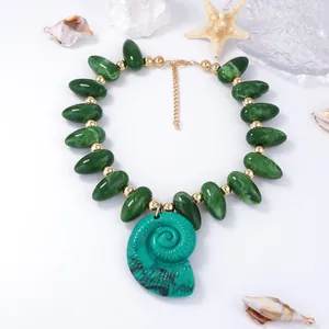 Détail du collier de perles avec gouttes texturées marbrées et pendentif de conque