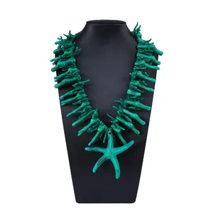 Gros plan détaillé sur le pendentif étoile de mer turquoise et collier corail synthétique