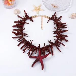 Gros plan du collier corail rouge avec grand pendentif étoile de mer et perles dorées
