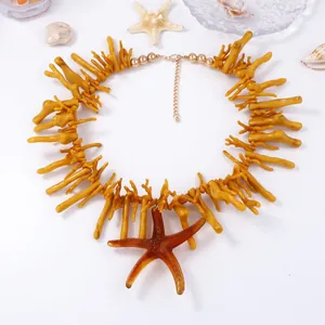 Vue détaillée des branches de corail jaune et pendentif étoile de mer avec fermoir doré