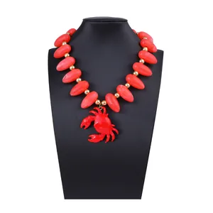 Détail macro du collier de perles créatif avec pendentif crabe rouge sur un buste noir