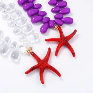 Colorful ocean style beaded necklace featuring clear and purple beads with a red starfish charm