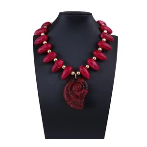 Détail macro de perles en résine rouge et pendentif nautile en spirale sur collier