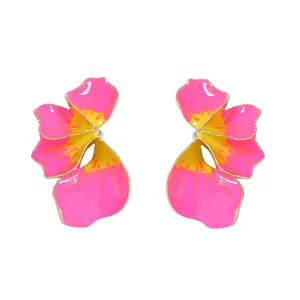 Dettaglio macro di orecchini a fiore 3D con petali di smalto rosa e centro arancione