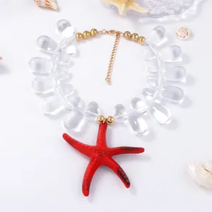 Macro shot of red starfish pendant and transparent teardrop beads on a nautical necklace
