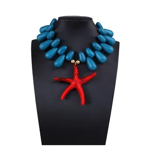 Detail of blue resin teardrop beads and a red starfish pendant on a beach style necklace