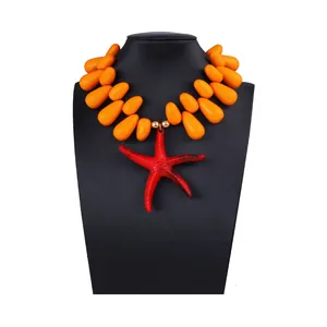 Detail of red starfish pendant and orange water-drop beads on a long vacation necklace