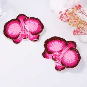 Macro shot of 3D orchid flower earrings with pink enamel finish and petal texture