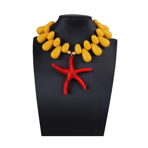 Detail of vibrant yellow teardrop beads and a red starfish pendant on a black bust stand