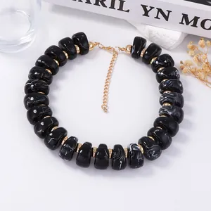Détail de perles à motif marbre noir avec entretoises et chaîne en métal doré