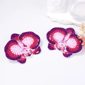 Detailed view of purple enamel orchid earrings with a glossy gradient finish on flower petals