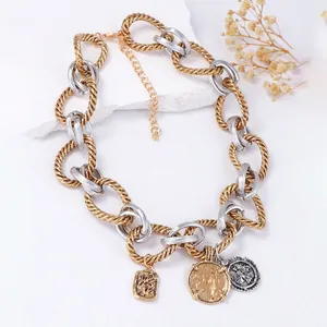 Détail du collier chaîne bicolore avec pendentifs pièces vintage et maillons texturés
