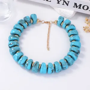 Détail du collier de perles turquoise bleues avec entretoises dorées et fermoir