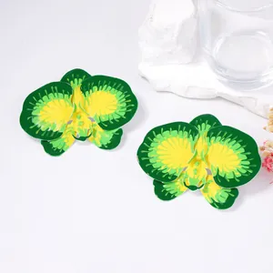 Macro detail of orchid flower earrings featuring green and yellow enamel finish