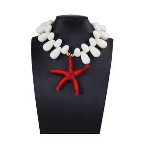 Macro detail of red starfish pendant and white teardrop beads on a black neck bust