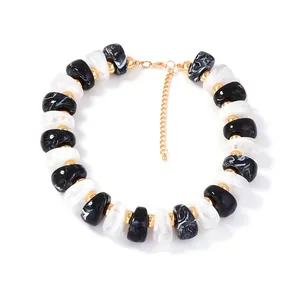 Collier de perles géométriques en résine marbrée noire et blanche avec détails dorés