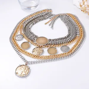 Macro shot of multi-layer mixed metal chain necklace with hammered coin pendants