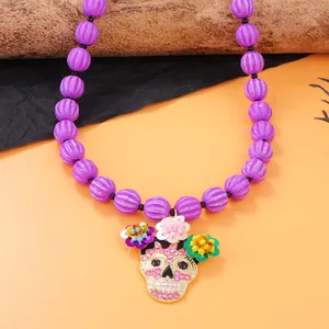 Makro-Detail der Halloween-Totenkopfkette mit lila Perlen und Zirkon-Blumen-Schädelanhänger