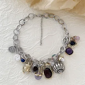 Vintage silver chain necklace featuring assorted bohemian charms and pearl pendants