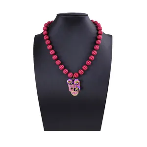 Halloween Perlenkette mit roten Kürbisperlen und rosa Strass-Totenkopf-Anhänger