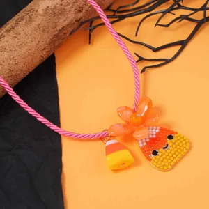 Collana di Halloween con ciondoli a forma di mais candito e cordino rosa su sfondo arancione