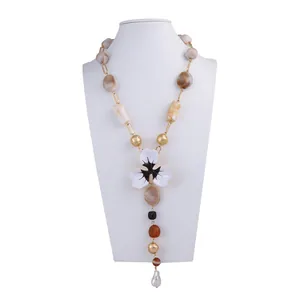 Dettaglio della collana a Y boho con pendente floreale e perline in resina su un busto