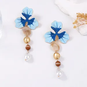 Dettaglio dell'elegante collana a Y con fiori in smalto blu e perle barocche lucide