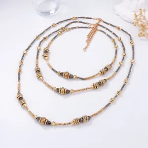 Detail of layered geometric CCB beaded necklaces with metallic gold and gunmetal tones