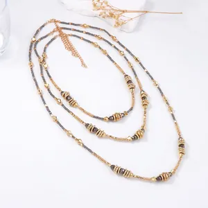 Three-layer CCB geometric beaded necklace in gold and dark grey with adjustable clasp