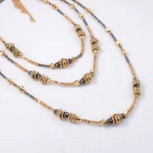 Chic multi-layered gold beaded necklace with geometric charms and adjustable clasp