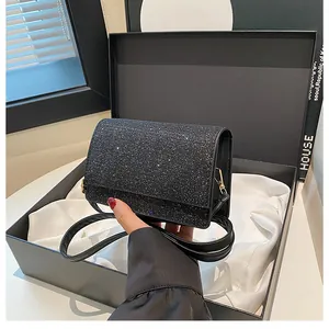 Detailansicht einer funkelnden schwarzen Glitzertasche in einer schwarzen Geschenkbox