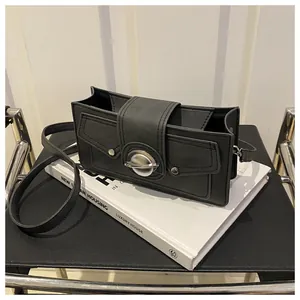 Détail du sac bandoulière noir en similicuir avec boucle planète en métal et rabat enveloppe