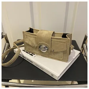 Détail du sac bandoulière en toile kaki avec anneau planète et poches frontales