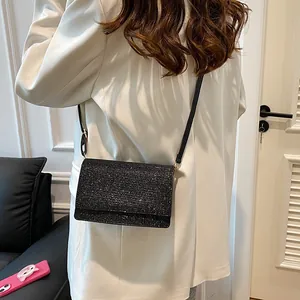 Funkelnde schwarze Glitzer-Umhängetasche für Damen auf elegantem weißen Blazer