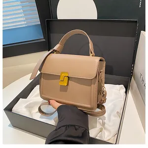 Detail of khaki leather handbag with gold square lock and adjustable shoulder strap