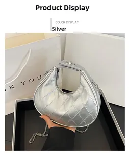 Détails d'un sac demi-lune argenté avec motif matelassé et bandoulière en chaîne