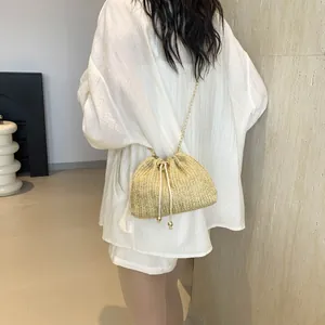 Borsa a secchiello in paglia intrecciata con catena dorata e coulisse per vacanze al mare