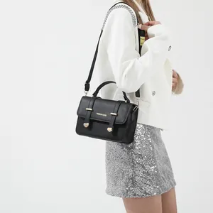 Minimalist black crossbody square bag for women with gold hardware and flap closure