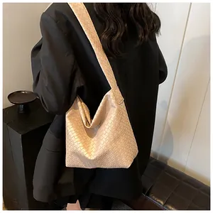Detail der handgewebten beigen Leder-Hobo-Tasche mit breitem Schultergurt und viel Platz