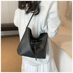 Detail of black ballet-style shoulder bag with elegant criss-cross lace decoration