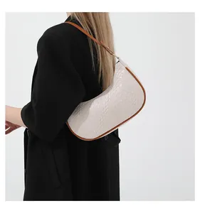 Detail of hobo bag with crocodile embossed leather and contrast brown shoulder strap